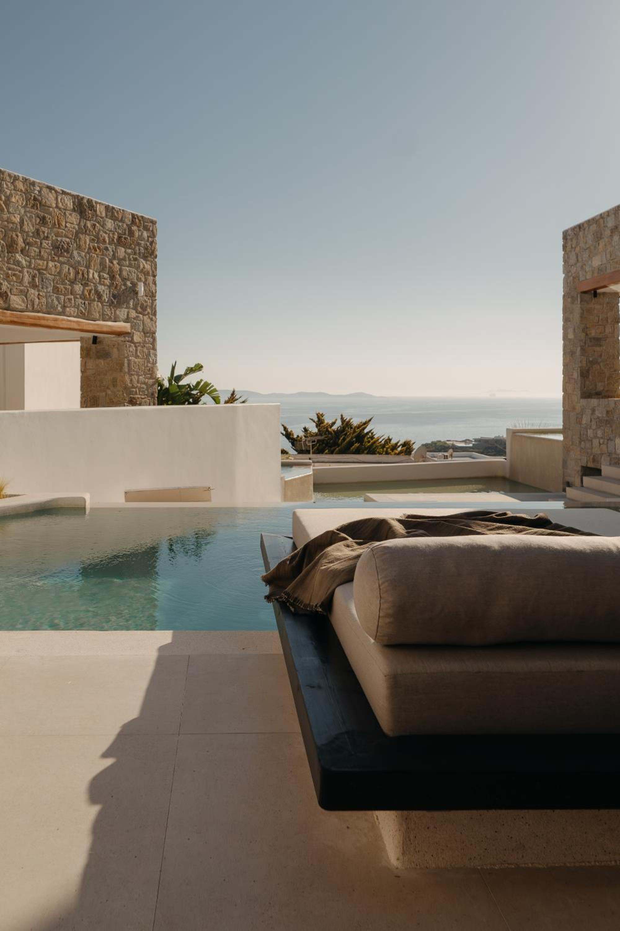 A daybed beside an infinity-edge pool, with the sea beyond