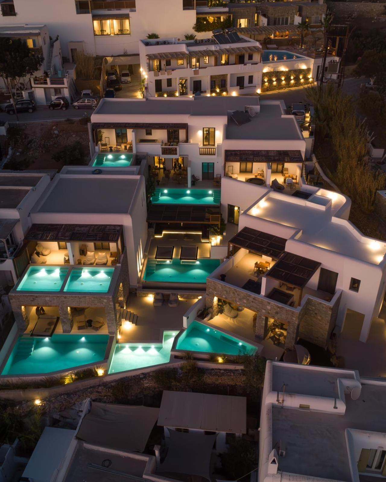 Aerial view of the hotel at night, its pools lit turquoise between the terraces