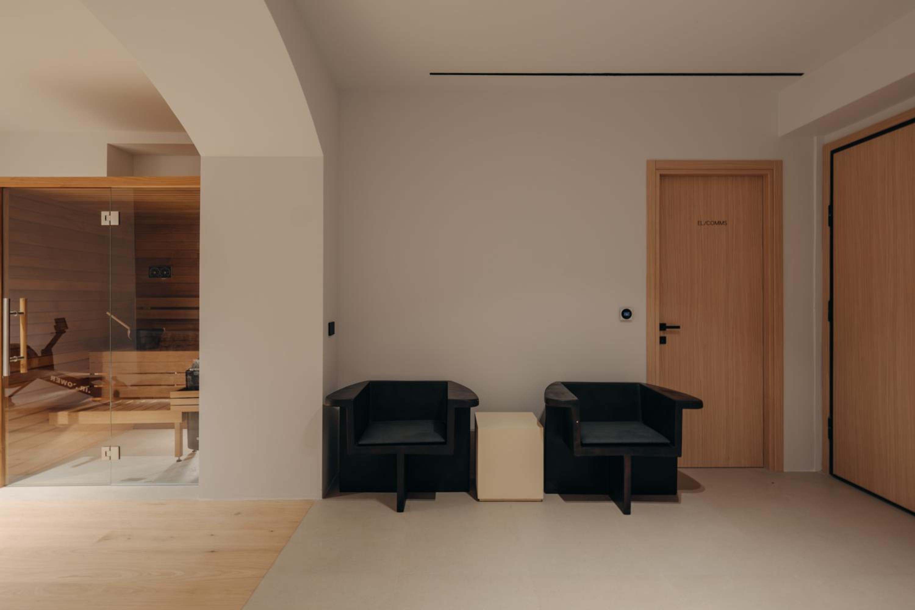 A timber-lined sauna beside a quiet seating area