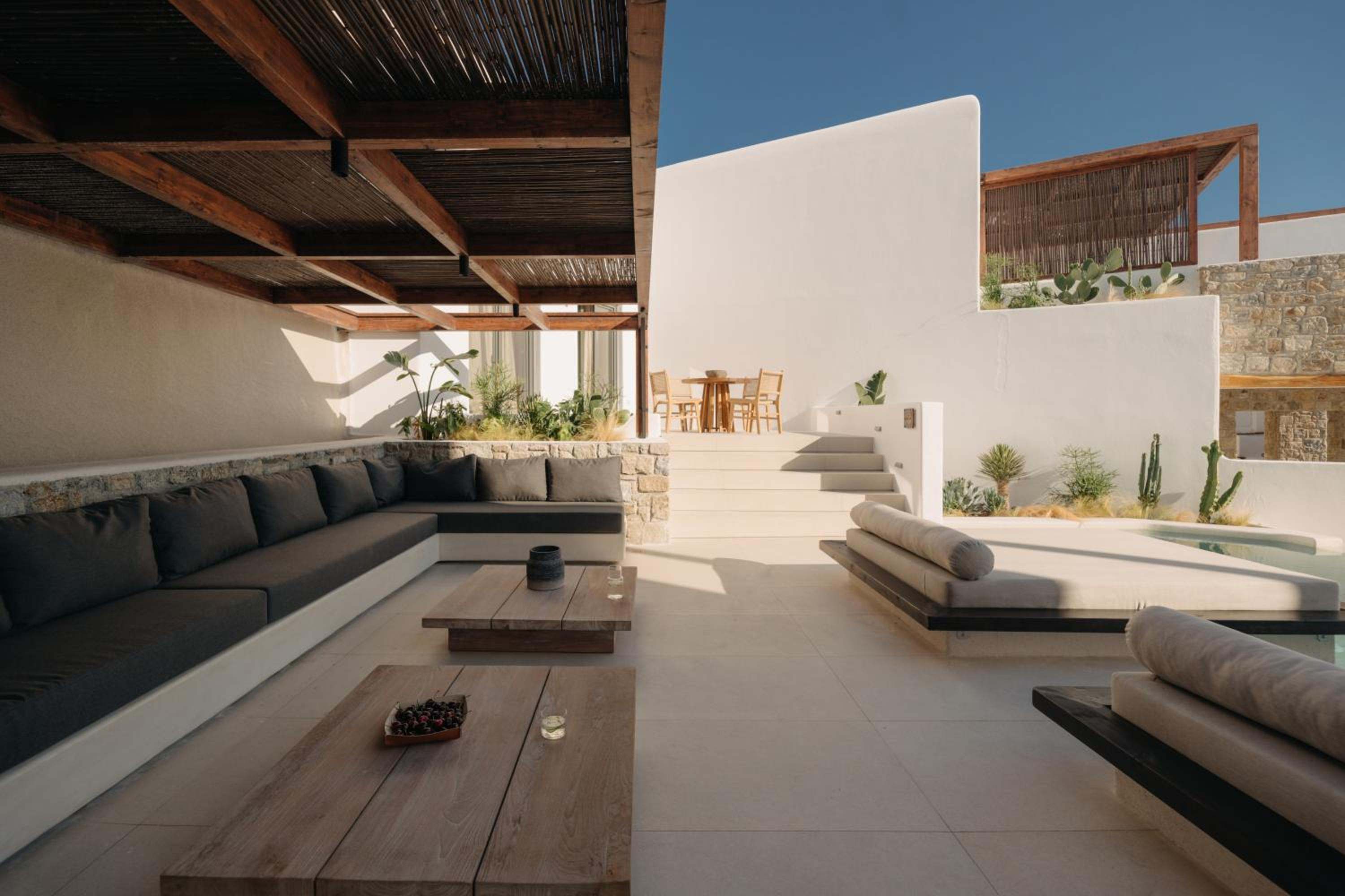 Del Sol Suite: a shaded outdoor lounge with built-in seating under a timber pergola