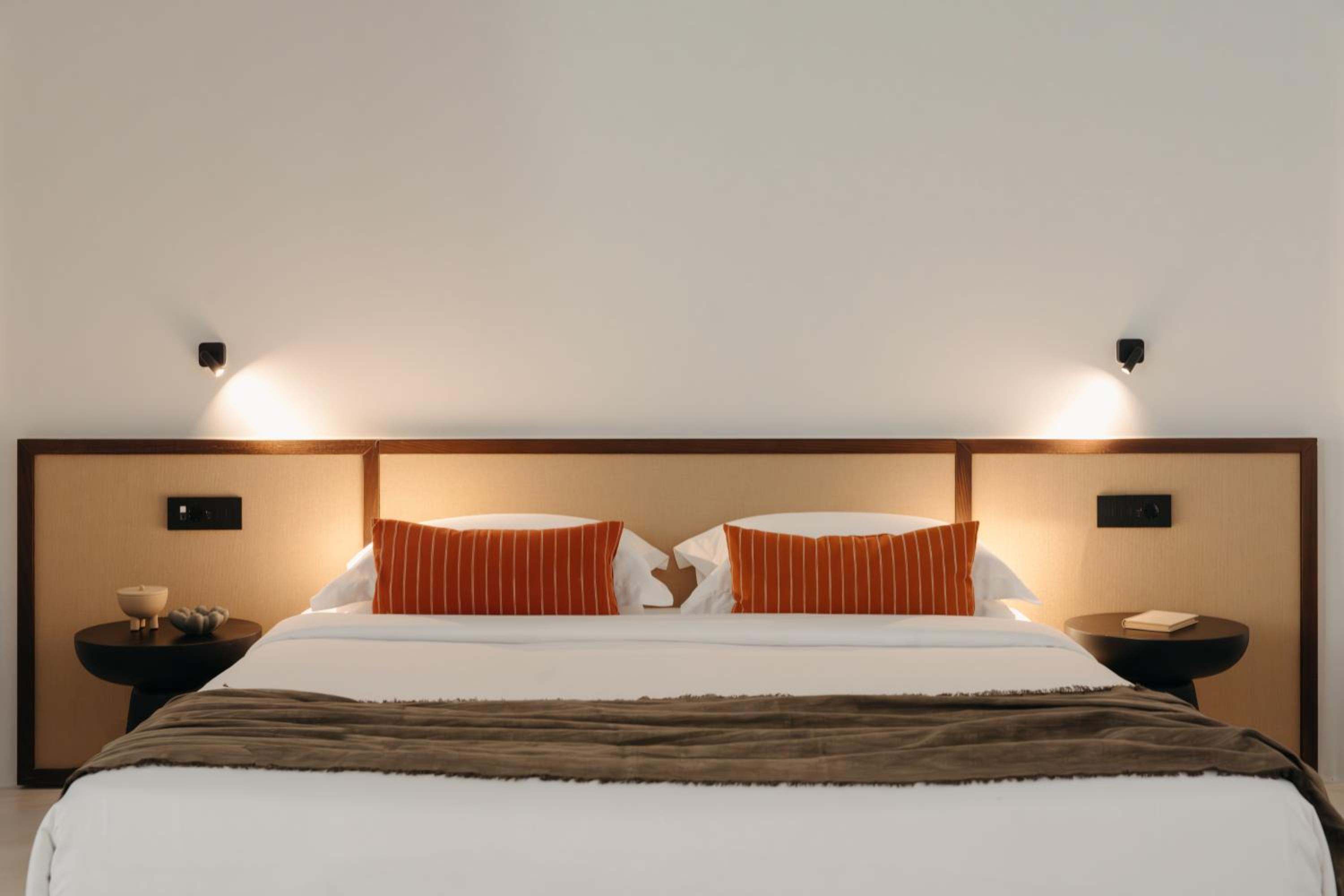 Del Sol Suite: a double bed with a woven headboard and reading lights