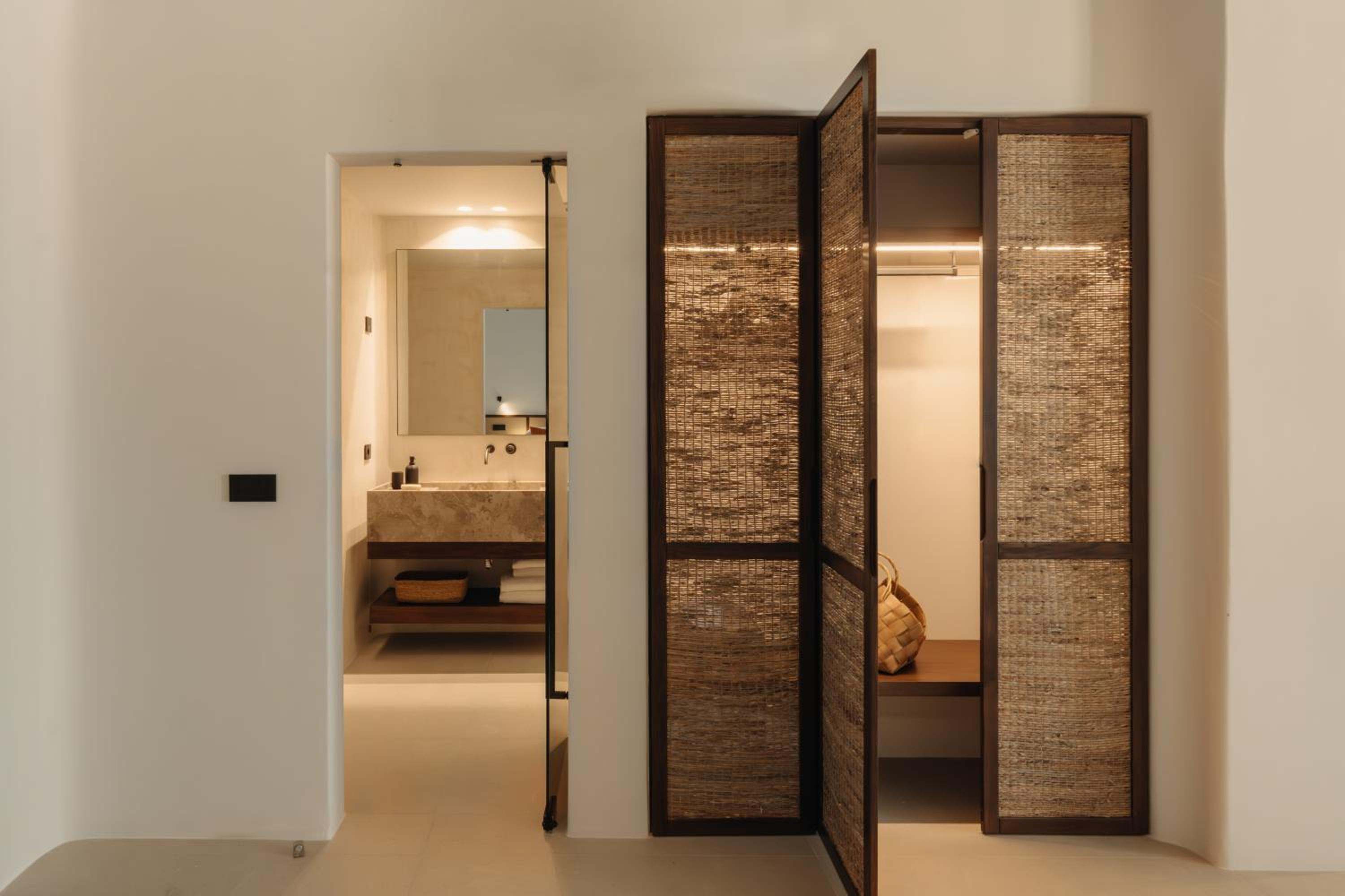 Del Sol Suite: a woven wardrobe door beside the bathroom entrance