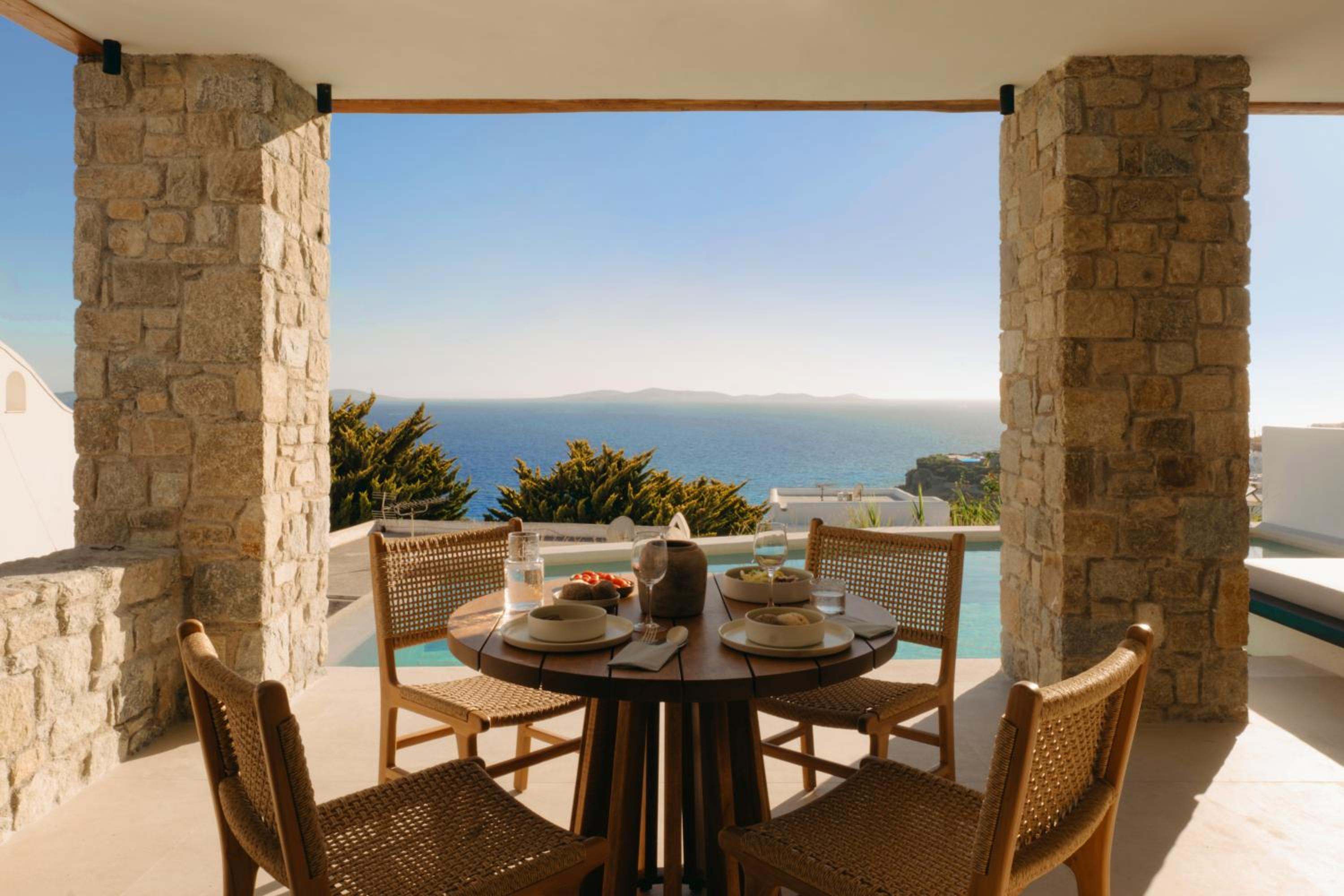 Premier Suite: a table set for lunch on the covered terrace, facing the sea