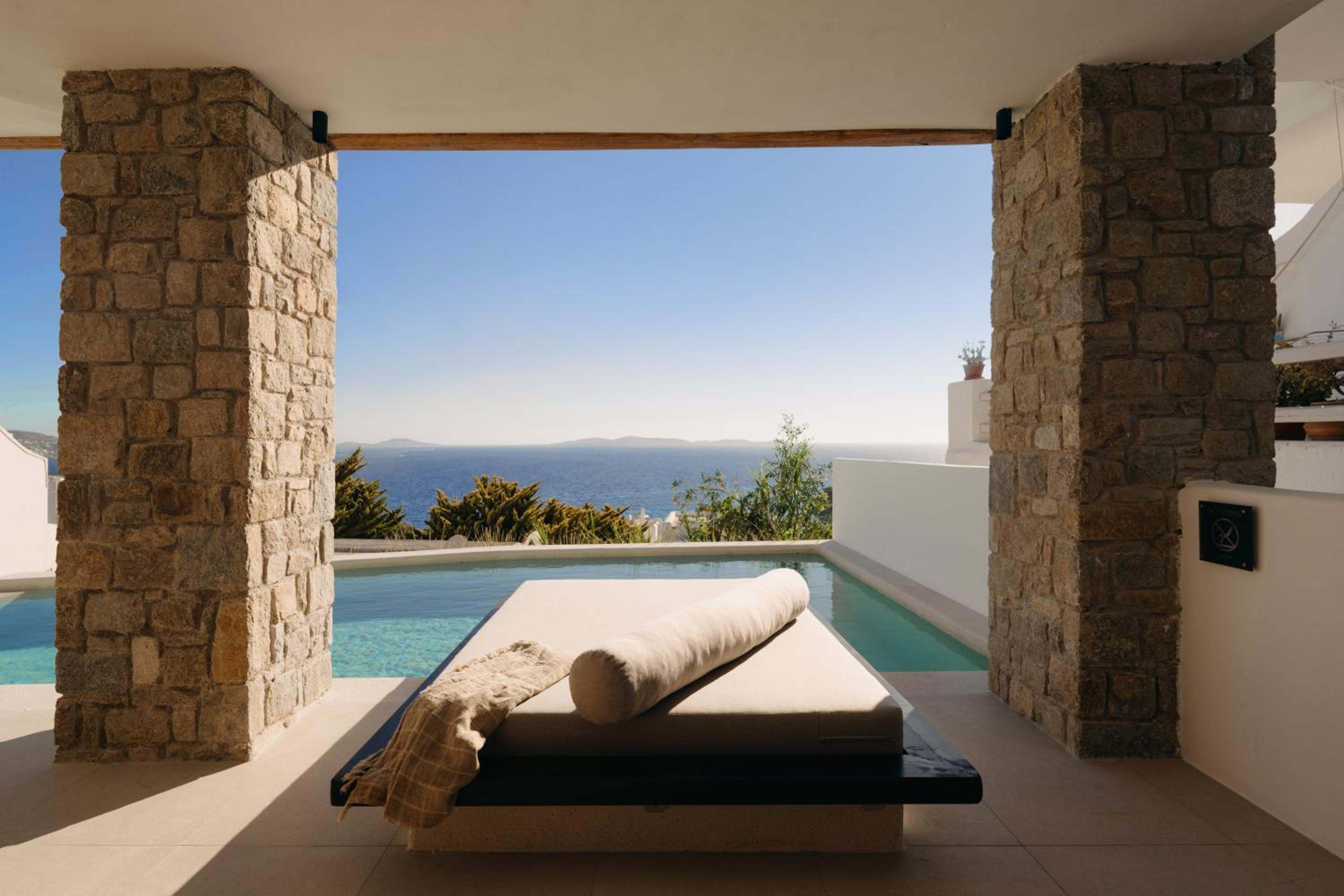 Premier Suite: a daybed beside the private pool between stone columns