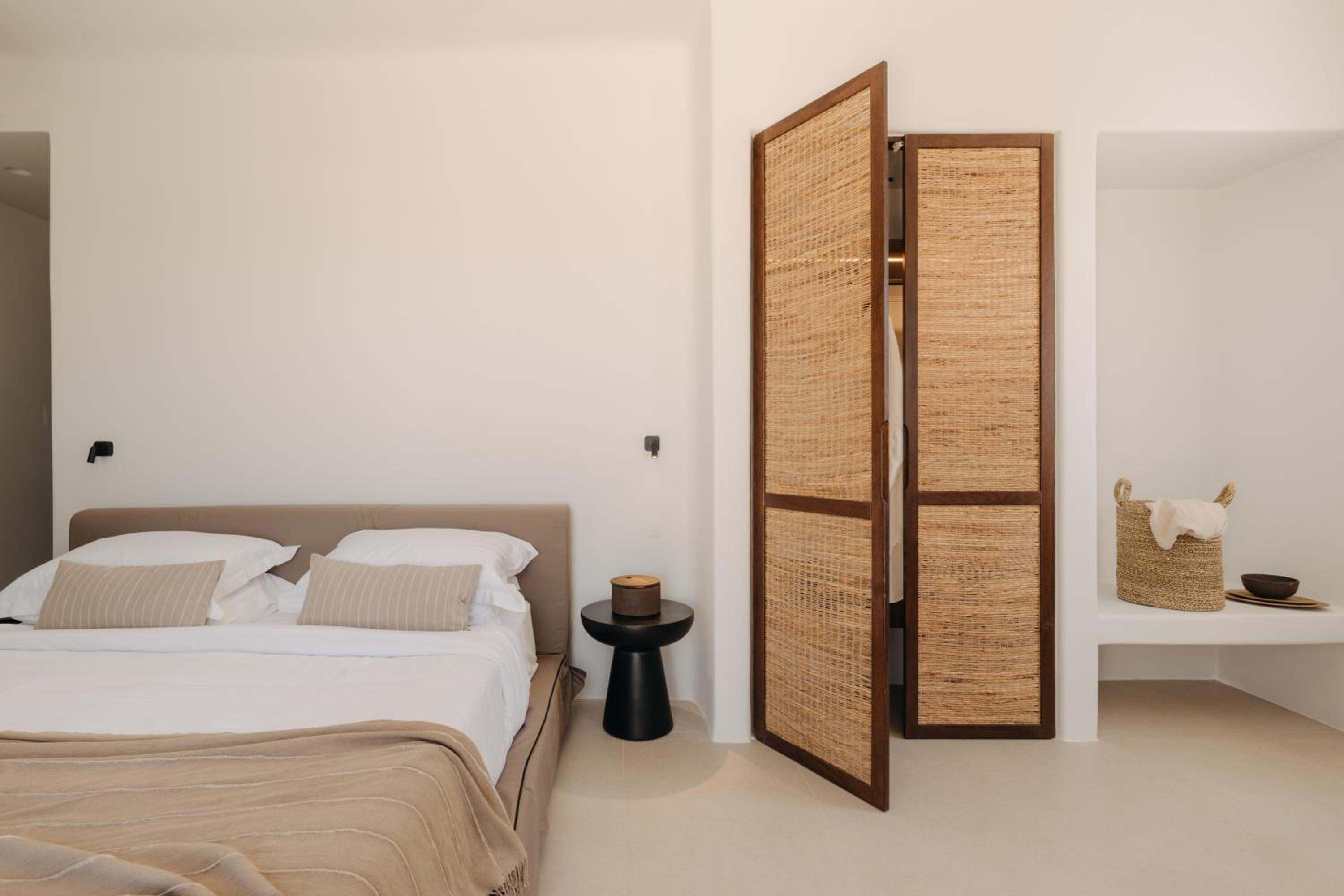 Junior Suite with Outdoor Hot Tub: the bed beside a woven wardrobe