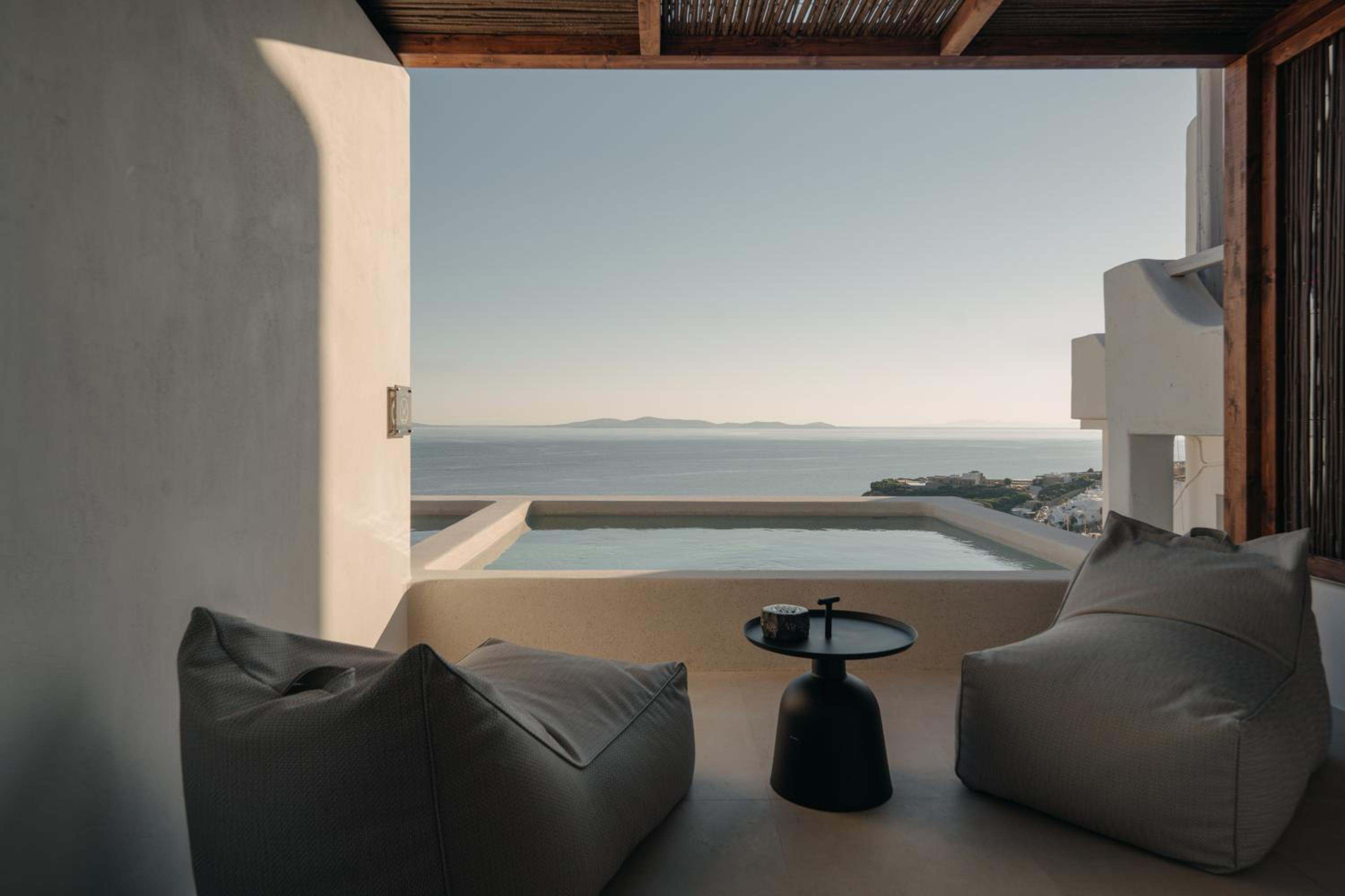 Junior Suite with Private Pool: low cushions on the covered terrace looking over the pool to the sea