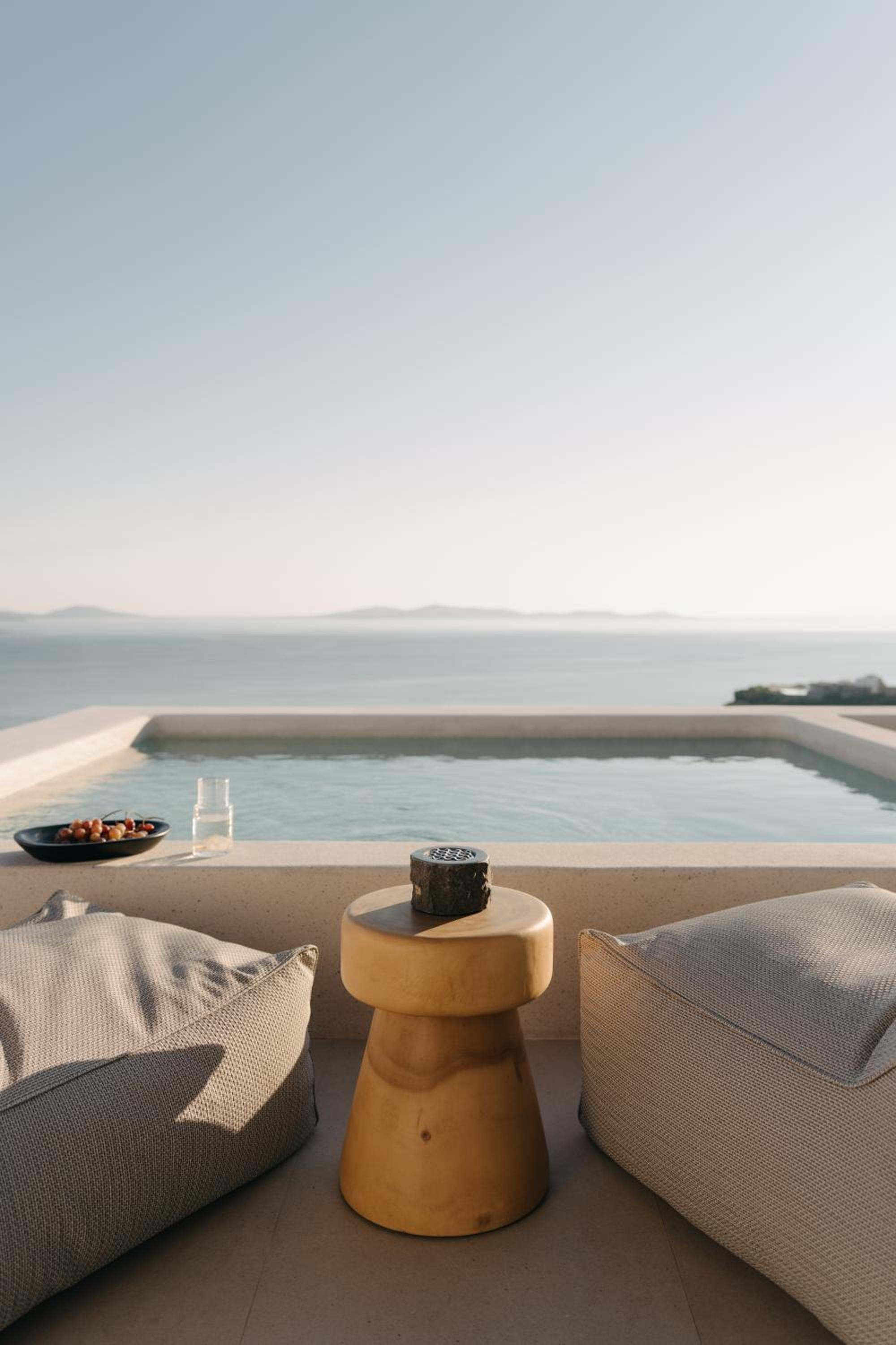 Junior Suite with Private Pool: cushions and a side table beside the pool at dusk