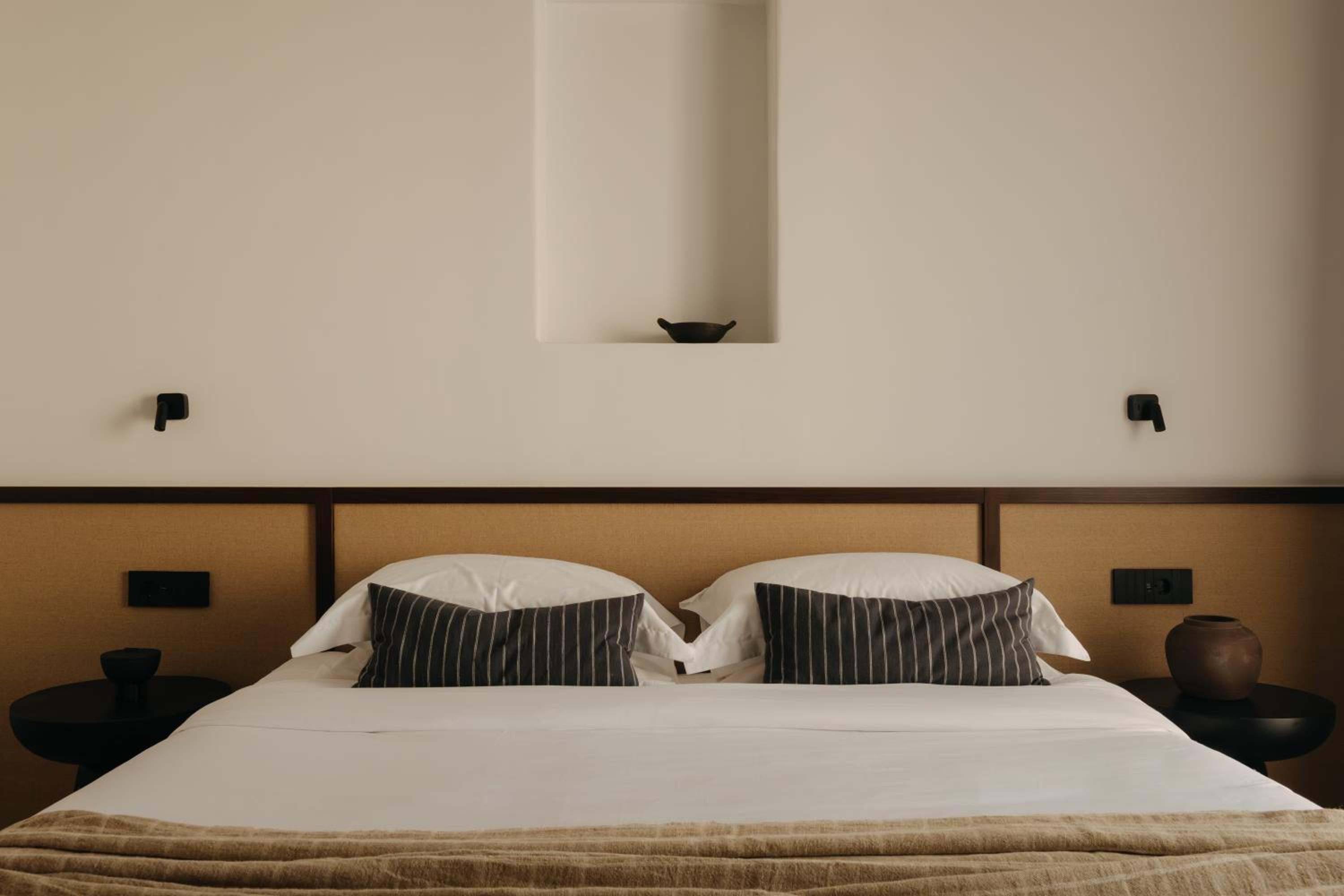 Deluxe Room: a double bed with a woven headboard