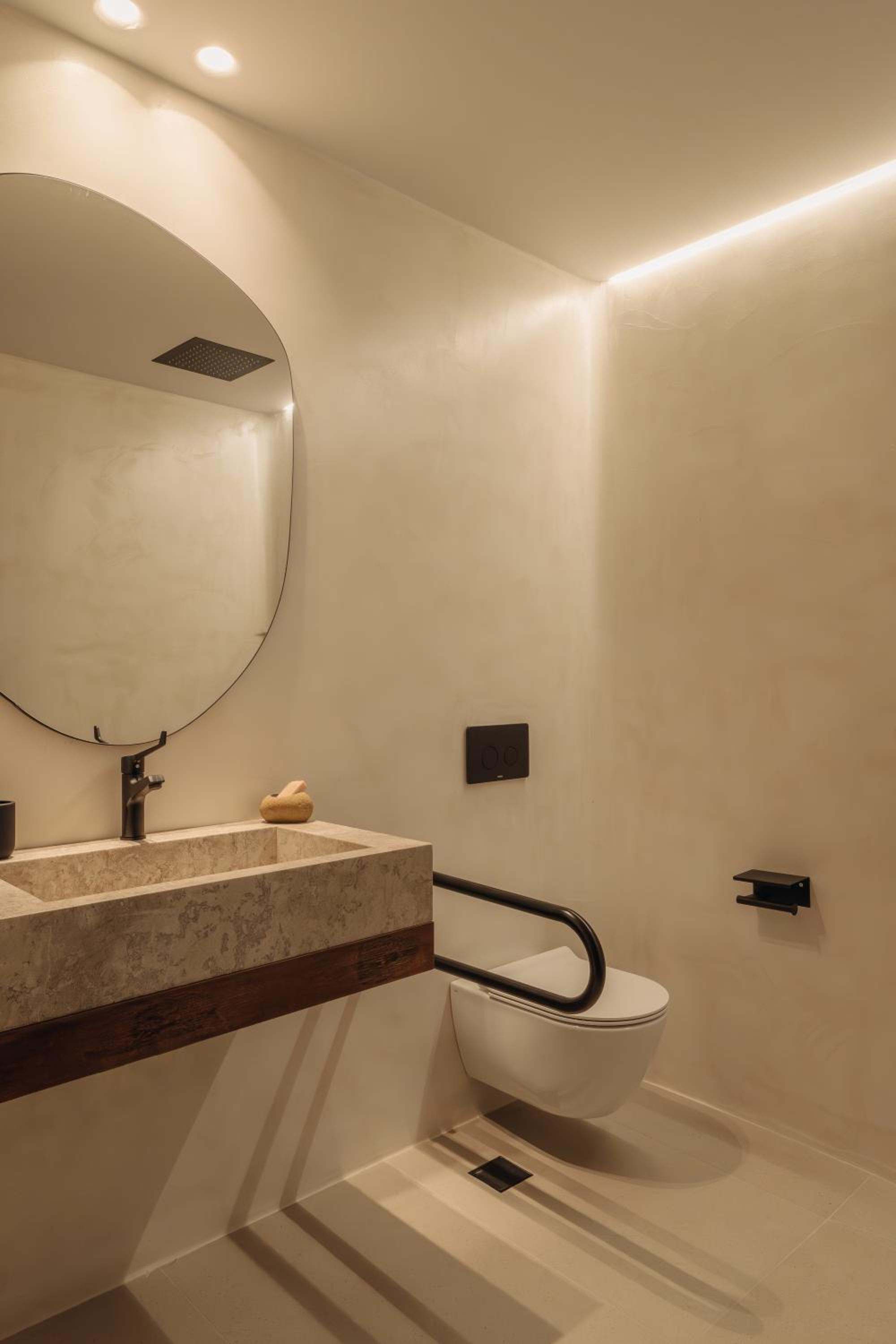 Deluxe Room: a stone basin beneath a curved mirror